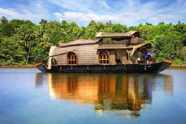 Traditional Kerala houseboat cruising palm-lined backwaters in Alleppey